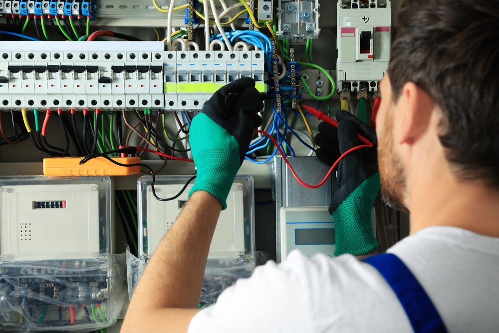 Electrician,checking,electric,current,with,multimeter,indoors,,closeup